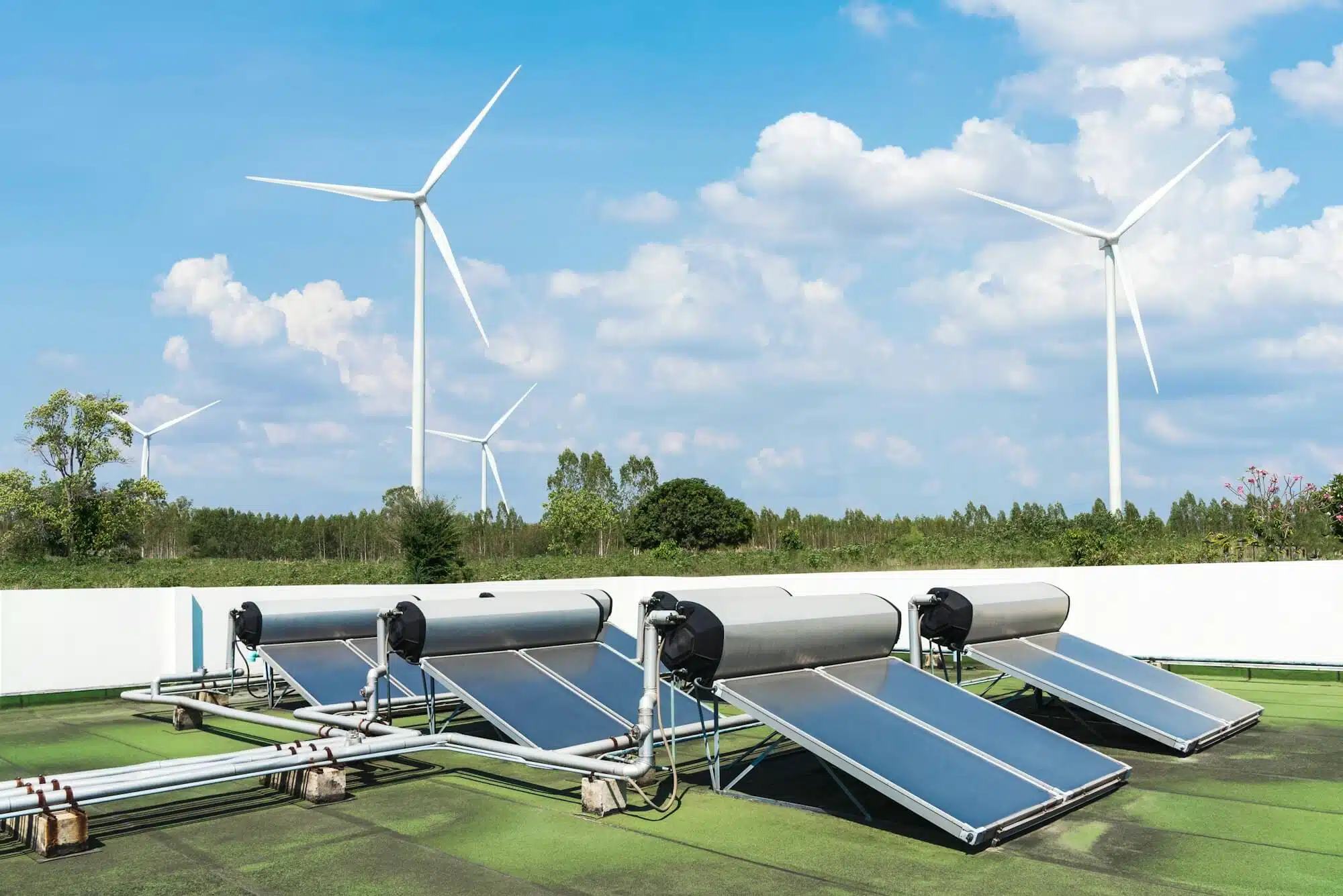 Solarmodule und Windkraftanlagen vor blauem Himmel – erneuerbare Energie